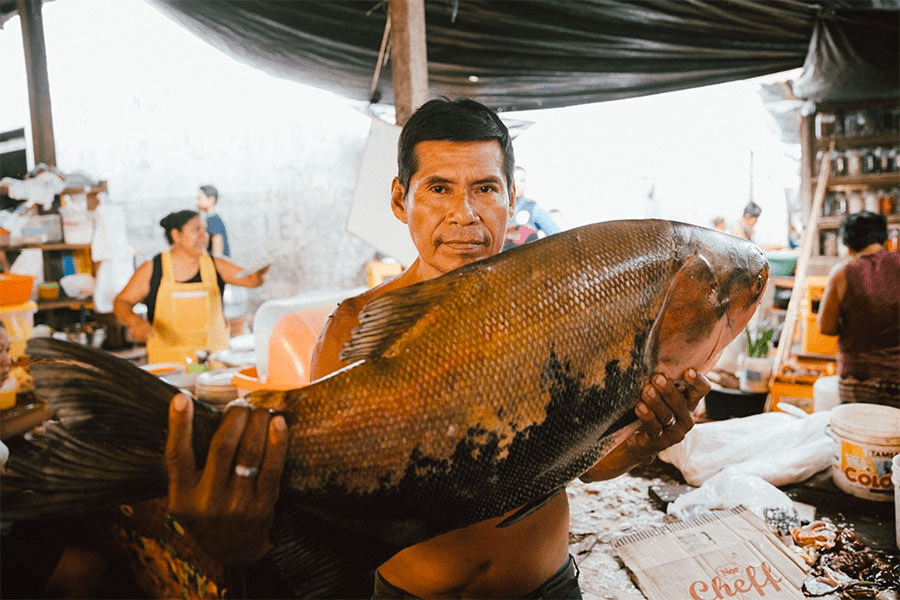 fisherman holding paiche